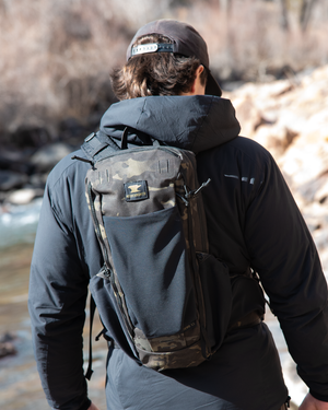 Close up of day pack shoulder strap with multiple pocket options showing cell phone carry on user's left strap
